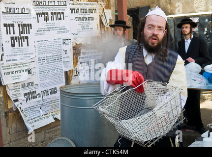 An Ultra Orthodox man is preparing to the Jewish holiday of Passover by purification of the dishes in Jerusalem Israel Stock Photo