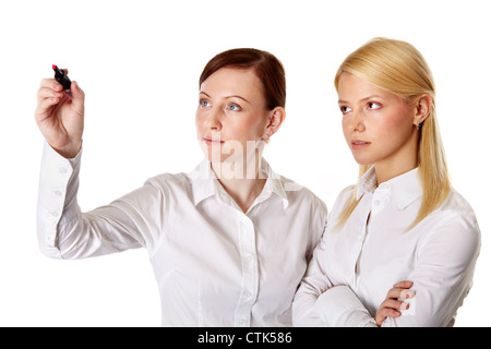 Business team of two pretty ladies writing on the screen with red marker, isolated on white Stock Photo