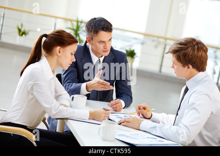 Mature team leader motivate young employee by gesture to share his business ideas Stock Photo