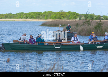 Norfolk Wildlife Trust. Water Trail Guide and electric boats, with visitors on board. Hickling Broad Nature Reserve. Norfolk. Stock Photo