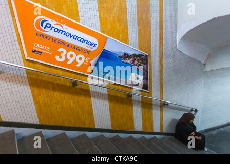 Paris, France, Woman Beggar on Stairs in Underground, French Travel Advertising france travel poster in Metro, poster advertising underground tube inside subway station wall, poster advertising underground tube Stock Photo