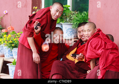 TIbetan monks smiling at camera in Ganzi monastery, Sichuan province, China Stock Photo