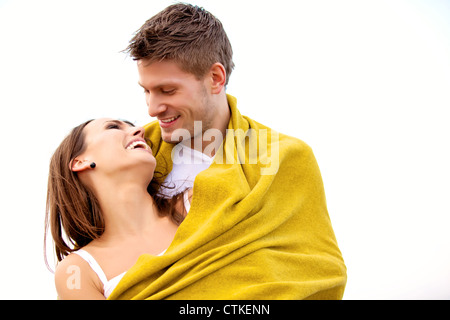 Portrait of a romantic couple embracing while wrapped with a blanket Stock Photo