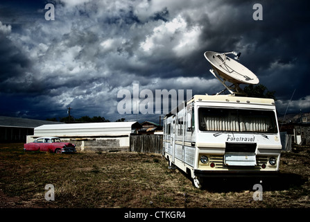 old camper with giant satellite dish on the roof against a stormy sky in utah, usa Stock Photo