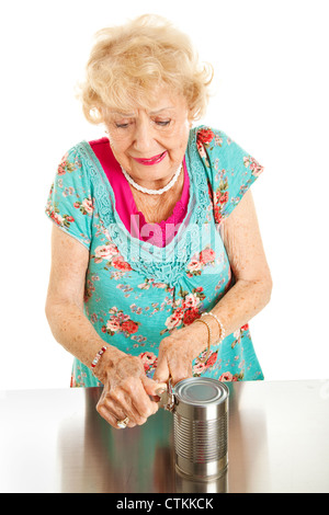 Senior woman with arthritis struggles to open a can.  Stock Photo