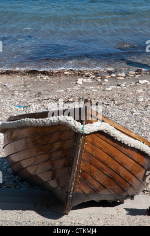 rowing boat on shingle beach re-varnished Stock Photo