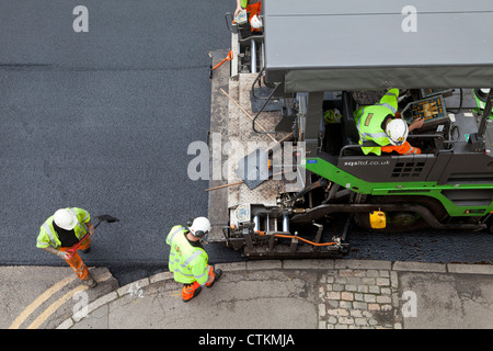 Road being resurfaced with new layer of tarmac asphalt Stock Photo