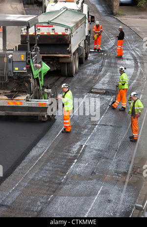 Road being resurfaced with new layer of tarmac asphalt Stock Photo