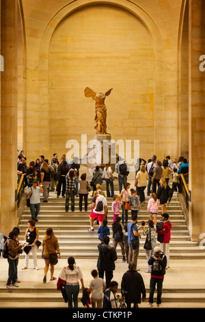 Tourists crowd around statue of Winged Victory 'Victoire de Samothrace' in the Musee du Louvre, Paris France Stock Photo