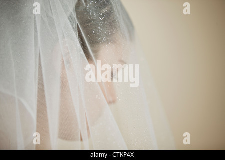 A young bride wearing a tiara and veil, looking down Stock Photo
