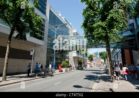 Cross Street in Manchester city centre busy with shoppers on a sunny clear sky day. Stock Photo