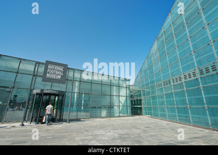 A visitor enters the National Football Museum (Urbis) in Manchester on a clear sunny summer's day. Stock Photo