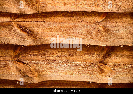 Close up of a wooden fence. Reddish brown in color, and made from horizontal slats. This fence is in a rear garden Stock Photo