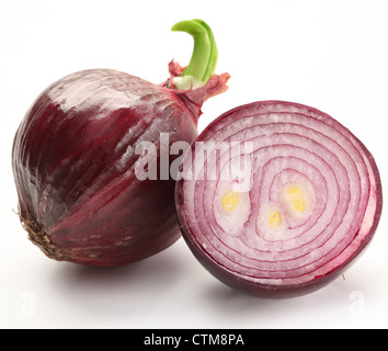 Bulbs of red onion with green leaves on a white background. Stock Photo