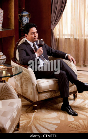 Mature businessman enjoying wine in a luxurious room Stock Photo