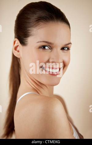 A young woman with brunette hair smiling to camera Stock Photo