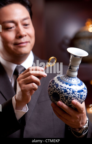 Mature businessman admiring an antique Chinese vase Stock Photo