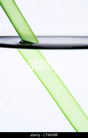 Drinking straw refracted by water Stock Photo