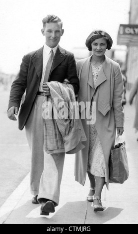 1930s COUPLE ARM IN ARM WALKING UP FROM OCEAN SMILING MAN IN WHITE ...