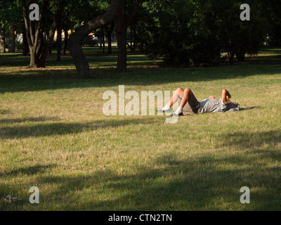 Man lying down resting in a park Stock Photo
