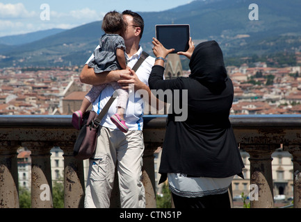Tourist takes holiday snap of family using iPad, Florence, Italy Stock Photo