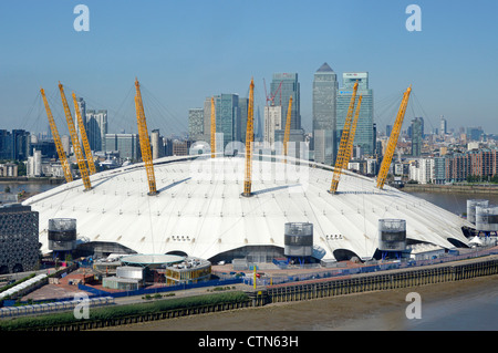 Aerial view O2 dome arena roof of London 2012 Olympic venue on the Greenwich Peninsula with Canary Wharf banking skyscraper skyline beyond England UK Stock Photo