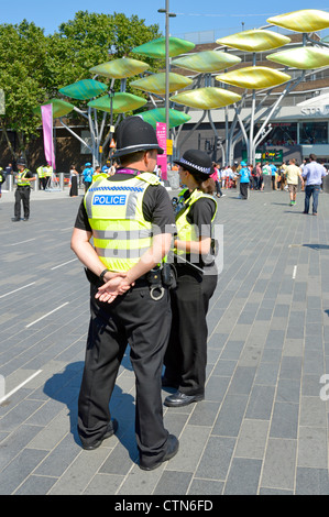 Police officers on duty at entrance concourse to the 2012 Olympic Park and the Westfield Stratford City shopping centre male & female wpc UK Stock Photo