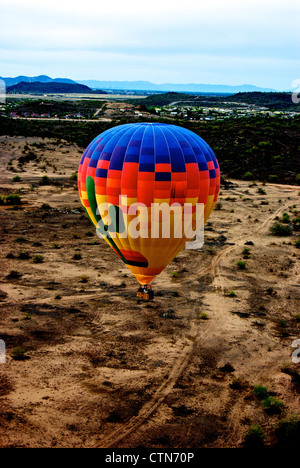 Hot Air Expeditions balloon floating over Sonoran Desert landscape Scottsdale AZ just after sunrise Stock Photo