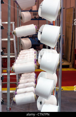 Group of bobbin thread cones on a warping machine in a textile mill ...