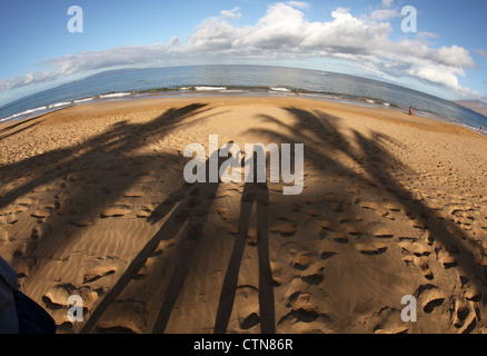 Couple making a heart shape with their hand shadows on a beach, Maui, Hawaii. Stock Photo