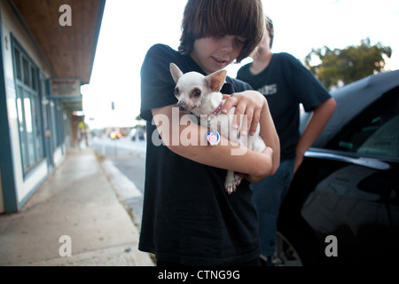 Ten year old boy holding a white chihuahua. Stock Photo
