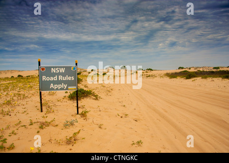 'NSW Road Rules Apply' sign on sand track through Stockton Dunes Near Newcastle New South Wales (NSW) Australia Stock Photo
