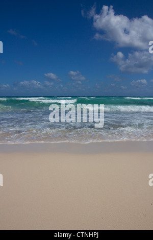 Small waves wash ashore at a perfect Caribbean beach under a clear blue Sky. Stock Photo
