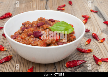 Chilli Con Carne in White Bowl and Red Chili Peppers Stock Photo