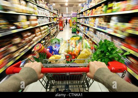 Food hall, full shopping trolley is pushed through a hallway with ...