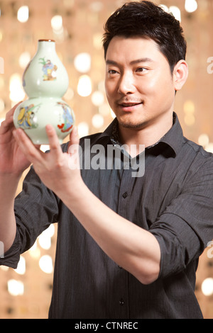 Man admiring antique Chinese vase Stock Photo