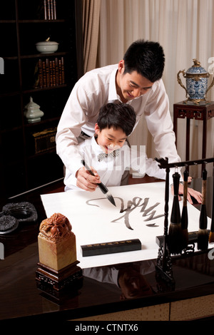 Father and son practising Chinese calligraphy Stock Photo