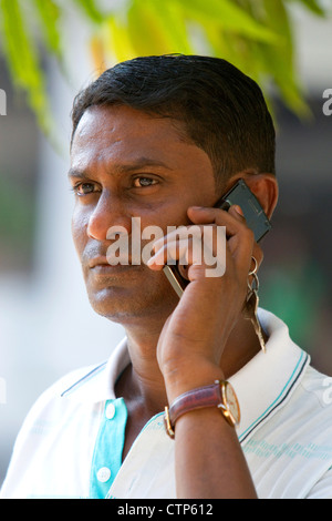 Burmese man using a cell phone in (Rangoon) Yangon, (Burma) Myanmar. Stock Photo