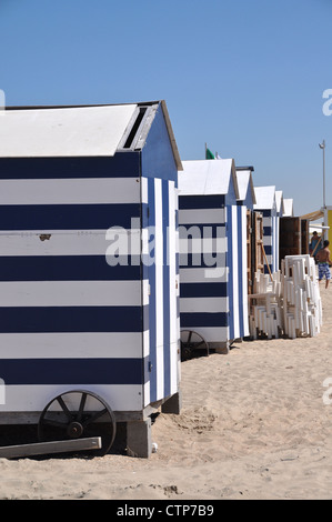 Blue-white striped beach cabins on the beach of De Panne, Belgium Stock Photo