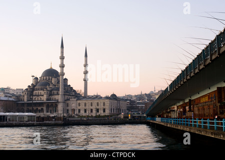 Fishermen at Galata Bridge and the New Mosque at morning dusk, Istanbul, Turkey Stock Photo