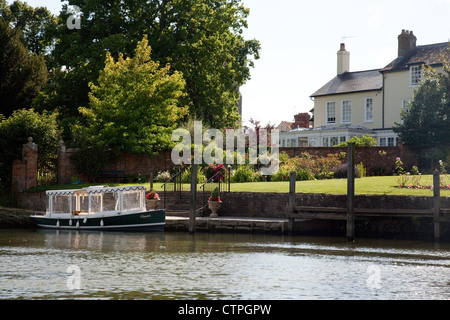 An electric boat moored by a house on the River Thames at Wallingford, Oxfordshire, UK Stock Photo