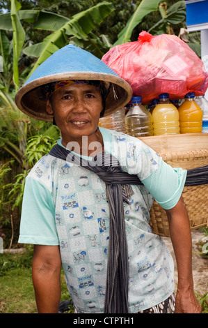 local female villager in rural village street with basket of local womens jamu drinks for sale Stock Photo