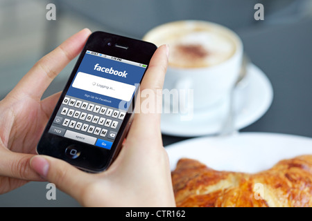 Close up view of female handholding an ipad logging in to her Facebook account Stock Photo