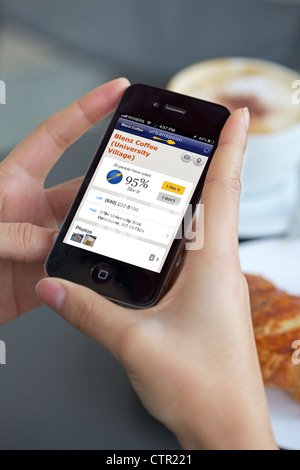 Close up view of a woman reading food and drink review of a restaurant using iphone 4 app Stock Photo