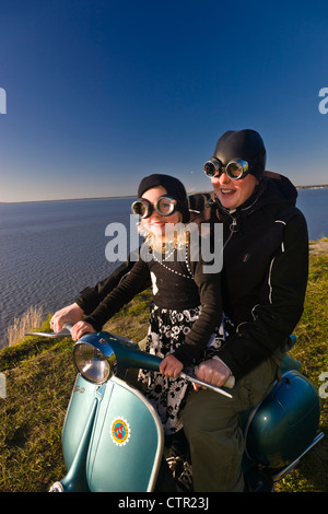 Mother and daughter wearing goggles and riding a vintage Vespa, Pt. Woronzof, Cook Inlet, Anchorage, Southcentral Alaska, Summer Stock Photo