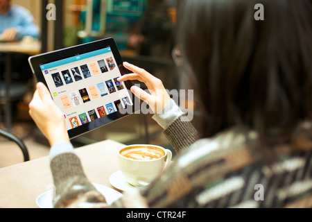 Close up view of female handholding an ipad browsing digital books on Kobo app Stock Photo