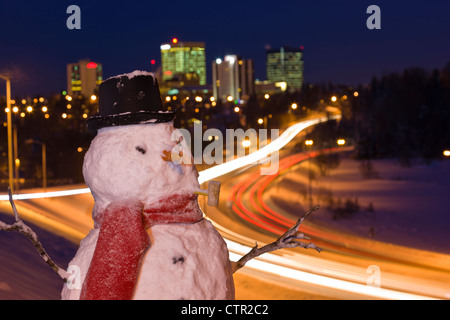 View traffic downtown Anchorage close up snowman in foreground Southcentral Alaska Winter Digitally enhanced. Stock Photo