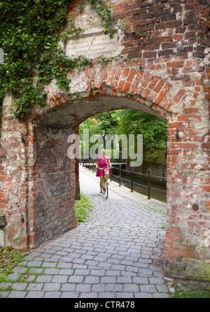 Woman riding bicycle in Memmingen, Bavaria, Germany, Europe Stock Photo