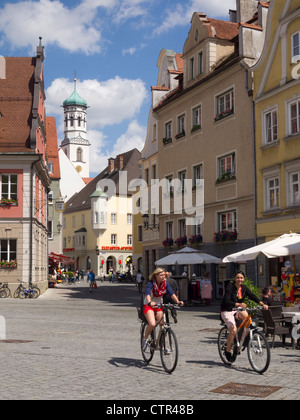 Two young women riding bicycles in the streets of Memmingen, Bavaria, Germany, Europe Stock Photo