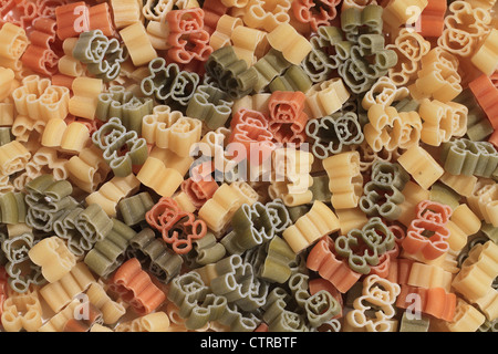 Italian pasta of durum wheat semolina with tomato and spinach in form of teddy bears. Funny for children. Stock Photo